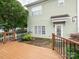 View of the spacious wood deck which overlooks the home's yard, and the AC unit alongside the back door at 13604 Morehouse St, Huntersville, NC 28078