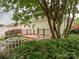 Private backyard featuring a wooden deck, white picket fence, lush greenery, and partial shade from mature trees overhead at 13604 Morehouse St, Huntersville, NC 28078