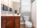 Functional bathroom with dark wood vanity, shower and toilet, providing essential amenities at 13604 Morehouse St, Huntersville, NC 28078