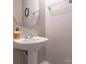 Neat powder room featuring a pedestal sink, oval mirror, and essential fixtures at 13604 Morehouse St, Huntersville, NC 28078