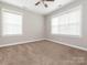 Bright bedroom with neutral walls and carpet features two windows that provide plenty of natural light at 13604 Morehouse St, Huntersville, NC 28078