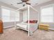 Comfortable bedroom featuring a four-poster bed, ceiling fan, and ample natural light at 13604 Morehouse St, Huntersville, NC 28078