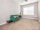 Bedroom features neutral carpet, a bright window, and a stylish green couch for a comfortable living area at 13604 Morehouse St, Huntersville, NC 28078
