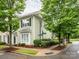 Green townhome with bay window and black shutters, framed by lush greenery and a street sign, blending suburban comfort at 13604 Morehouse St, Huntersville, NC 28078