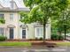 Charming townhome featuring light green siding, bay window, and a black front door, nestled beneath the shade of a mature tree at 13604 Morehouse St, Huntersville, NC 28078