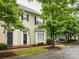 Charming townhome featuring light green siding, bay window, and a black front door, nestled beneath the shade of a mature tree at 13604 Morehouse St, Huntersville, NC 28078