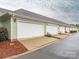 Row of attached one car garages with individual driveways and manicured landscaping enhancing curb appeal at 13604 Morehouse St, Huntersville, NC 28078