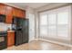 Kitchen showcasing wood cabinets, black appliances and a window with white shutters providing ample natural light at 13604 Morehouse St, Huntersville, NC 28078