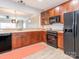 Traditional kitchen design with wood cabinets and black appliances, including range, microwave and refrigerator at 13604 Morehouse St, Huntersville, NC 28078