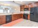Open kitchen showcasing wood cabinets, sleek black appliances, and light wood-look flooring, blending style and functionality at 13604 Morehouse St, Huntersville, NC 28078
