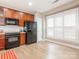 Bright kitchen featuring wood cabinets, black appliances, and a window with white shutters providing ample natural light at 13604 Morehouse St, Huntersville, NC 28078