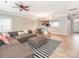 Open-concept living room featuring a ceiling fan and seamless flow to the dining and kitchen areas at 13604 Morehouse St, Huntersville, NC 28078