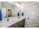 A modern bathroom features double sinks, quartz countertops, and a large mirror at 13708 Huntson Park Ln, Huntersville, NC 28078