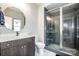 Bathroom with a double sink vanity, an oval mirror, and a glass-enclosed tiled shower at 13708 Huntson Park Ln, Huntersville, NC 28078