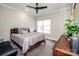 Bedroom boasts a comfortable bed, ceiling fan, large window, and a dark wood dresser at 13708 Huntson Park Ln, Huntersville, NC 28078