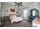 Comfortable bedroom boasts a plush bed, a vanity area with a tri-fold mirror, and carpeted floors at 13708 Huntson Park Ln, Huntersville, NC 28078