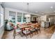 A modern dining room featuring a large wooden table, hardwood floors, and a view into the kitchen at 13708 Huntson Park Ln, Huntersville, NC 28078