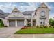 Beautiful stone-clad home with a three-car garage, lush lawn, and attractive landscaping at 13708 Huntson Park Ln, Huntersville, NC 28078