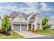 Beautiful stone home with a two-car garage and well-maintained landscaping at 13708 Huntson Park Ln, Huntersville, NC 28078