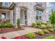 Inviting stone-clad front entrance with manicured landscaping, window box and an arched doorway at 13708 Huntson Park Ln, Huntersville, NC 28078