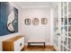 Hallway with hardwood floors, art, bench, cabinet, and view to a bright room at 13708 Huntson Park Ln, Huntersville, NC 28078
