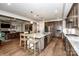 Bright kitchen features a large island with seating and open sightlines to the living area and fireplace at 13708 Huntson Park Ln, Huntersville, NC 28078