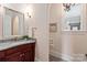 Elegant powder room featuring a granite countertop and wood vanity, complemented by a stylish mirror and sconce lighting at 1501 Alydar Ct, Waxhaw, NC 28173