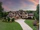 Stunning home with stone accents, lush landscaping, and a long driveway leading to a three-car garage at 1501 Alydar Ct, Waxhaw, NC 28173