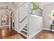Inviting hallway with hardwood floors, staircase, iron railing, and view into a dining room at 1501 Alydar Ct, Waxhaw, NC 28173