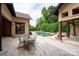 Inviting outdoor living area featuring a pool, stone patio, dining set, and covered space with fireplace at 1501 Alydar Ct, Waxhaw, NC 28173