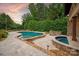Beautiful kidney-shaped in-ground pool and hot tub surrounded by lush landscaping at 1501 Alydar Ct, Waxhaw, NC 28173