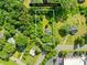 Aerial view of a tree-filled lot in a charming neighborhood and adjacent commercial area at 1528 Avondale Dr, Statesville, NC 28625