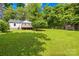 A spacious backyard is accentuated with trees, a deck, and a storage building at 1528 Avondale Dr, Statesville, NC 28625