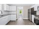 Bright kitchen features white cabinetry, stainless steel refrigerator, granite counters, and modern subway tile backsplash at 1528 Avondale Dr, Statesville, NC 28625