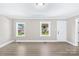 Bright living room featuring modern flooring, white trim, and ample natural light through two windows at 1528 Avondale Dr, Statesville, NC 28625