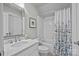 Well-lit bathroom with a shower-tub, white vanity, and a patterned shower curtain at 1629 Southpoint Ln, New London, NC 28127