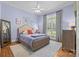 Cozy bedroom featuring a wooden bed frame, soft blue walls, and a window with natural light at 1629 Southpoint Ln, New London, NC 28127