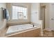 A luxurious bathtub with jets sits beneath a window, complemented by a separate shower at 1653 Shetland Ln, Rock Hill, SC 29730