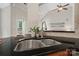 The kitchen sink features a black countertop, cherry cabinets and wood floors at 1653 Shetland Ln, Rock Hill, SC 29730