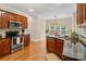 Well-lit kitchen boasts stainless steel appliances, dark countertops, and beautiful wood cabinets at 1653 Shetland Ln, Rock Hill, SC 29730
