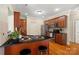 Kitchen island has a black countertop, cherry cabinets and wood floors at 1653 Shetland Ln, Rock Hill, SC 29730