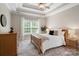 A spacious main bedroom with a ceiling fan, big window, and wood furniture at 1653 Shetland Ln, Rock Hill, SC 29730