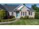 Close-up of charming front entrance with a bright blue door surrounded by lush greenery and manicured landscaping at 179 Browning Dr, Taylorsville, NC 28681
