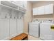 Well-organized laundry room with a bench, coat hooks, overhead cabinets, and modern washer and dryer at 179 Browning Dr, Taylorsville, NC 28681