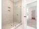 Bathroom featuring a modern walk-in shower with tile surround and a glass door leading to the closet and bedroom at 18019 Wilbanks Dr, Charlotte, NC 28278