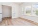 Bright bedroom with light wood floors and ample natural light from large windows and featuring a door to the side at 18019 Wilbanks Dr, Charlotte, NC 28278