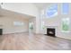 Bright, open-concept living room featuring a cozy fireplace, large windows, and light wood flooring at 18019 Wilbanks Dr, Charlotte, NC 28278