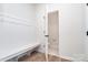 Convenient mudroom with built-in bench, coat rack and open doorway to a half bathroom at 18019 Wilbanks Dr, Charlotte, NC 28278