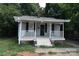 Charming home with a covered front porch with black shutters and gray vinyl siding at 2017 Ashley Rd, Charlotte, NC 28208