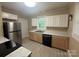 Renovated kitchen featuring stainless steel appliances, two-tone cabinets, and modern countertops at 2017 Ashley Rd, Charlotte, NC 28208